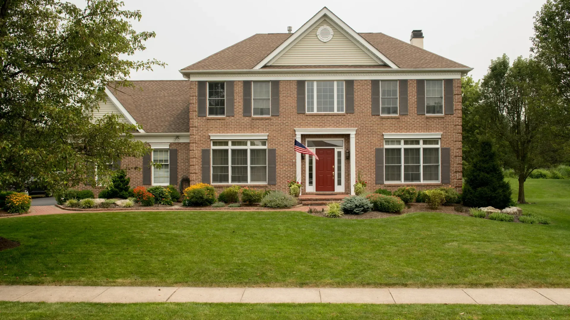 Summer-Front-Yard-with-Shrubs-Mulch-Garden-Beds-Paver-Path-Full-View-Landscape